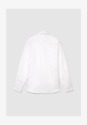 Chemise blanche à manches longues en coton, dotée d'un col classique, de poignets boutonnés et d'une texture lisse avec un détail de griffe dans le dos.