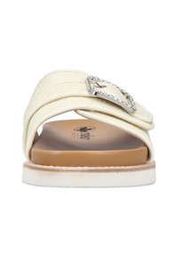 White slide sandal featuring woven straps, a silver geometric buckle with rhinestones, and a brown cushioned footbed. Flat sole with slight texture.