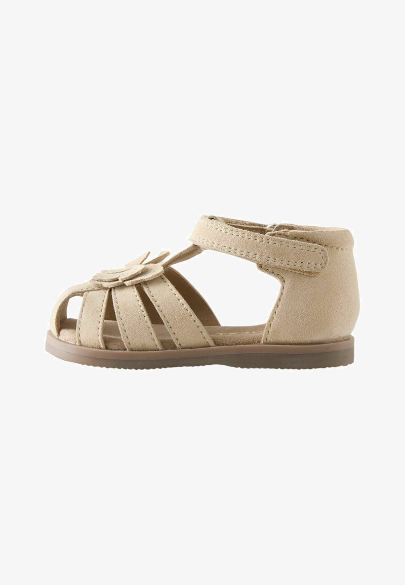 Sandale beige pour tout-petit avec talon fermé, plusieurs brides à l’avant, décoration fleurie et bride de cheville réglable à scratch.