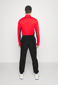 Nike Performance NIKE ACADEMY23 TRACK PANTS - Pantalones deportivos - black/white