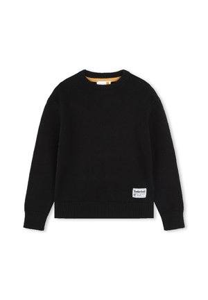 Pull en maille noir avec un col rond, des poignets et un ourlet côtelés, présentant une petite étiquette logo Timberland blanche sur le bas à gauche.