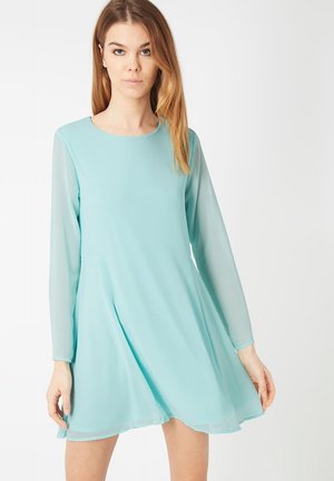 Un vestido de corte recto verde menta con mangas largas de tela transparente, escote redondo y una silueta en A fluida, hecho de tela ligera.