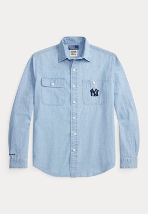 Svetlomodrá džínsová košeľa so zapínaním na gombíky, dvoma náprsnými vreckami a vyšívaným námorníckym logom NY na ľavom vrecku. Dlhé rukávy s gombíkovými manžetami.