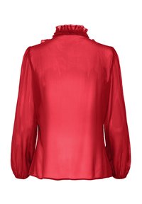 Piros áttetsző blúz hosszú, felfújt ujjakkal és fodros magas nyakkal. Sima textúrájú és bő szabású, egyenes alsó szegéllyel.