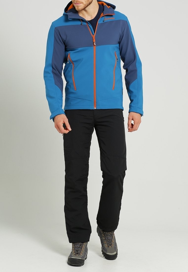 Blauwe en marineblauwe jas met een oranje rits; voorzien van een capuchon, twee voorzakken en lange mouwen. Gecombineerd met zwarte broek en grijze laarzen.