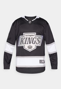 Los Angeles Kings hoki särk; must koos valgete aktsentidega, suur logo, hõbedane ääris ja V-kaelus. Kerge materjal.