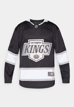 Jersey de hockey de Los Angeles Kings; negro con detalles en blanco, presenta un gran logo, ribetes plateados y un cuello en V. Tejido ligero.