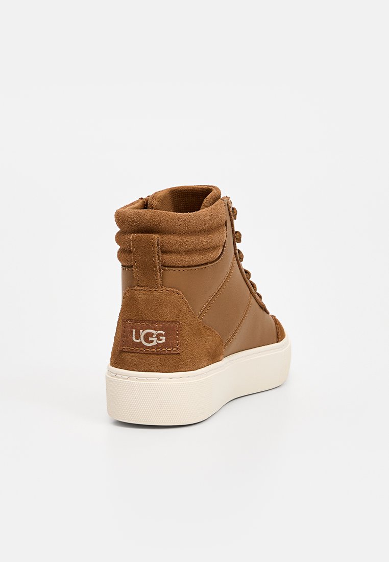 Bruine suede hoge sneakers met een textuurpaneel, witte rubberen zool en een logo-opdruk op de hiel. Vetersluiting met een geveerd kraagje.