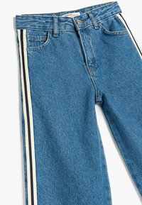 Blauwe denim jeans met een hoge taille, met twee verticale zijstrepen in zwart en wit. Klassiek vijfzakdesign, gestructureerde stof.