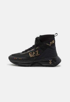 Schwarzer High-Top-Sneaker mit goldenem Emporio Armani EA7 Logo, Schnürung vorne und dicker geometrischer Sohle. Nummer 7.0 im Knöchelbereich.