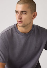 Γκρι κοντομάνικη μπλούζα από απαλό ύφασμα, με στρογγυλή λαιμόκοψη και διακριτικό λογότυπο Levi's στο μπροστινό μέρος. Λεία υφή, άνετη εφαρμογή.