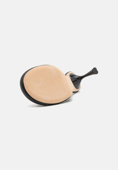 Sort højhælet sko med en glat overflade, spids tå og en beige ruskinds sål, som fremhæver et rent og minimalistisk design.