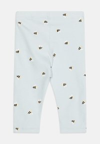 Leggings bleu clair avec une texture côtelée, arborant des motifs répétés de abeilles noires et jaunes. Ceinture élastique pour plus de confort.