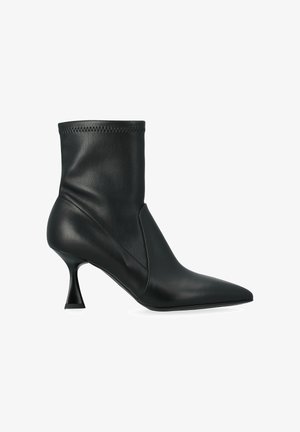 Botte stiletto en cuir noir mi-mollet avec un bout pointu et un talon haut, fin et évasé sur un fond blanc.