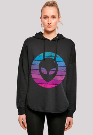 Schwarzer Kapuzenpullover mit abgerundetem Saum, der ein verlaufendes Alien-Logo in blauen und rosa Streifen zeigt. Das Material scheint weich zu sein; er ist mit Kordeln ausgestattet.