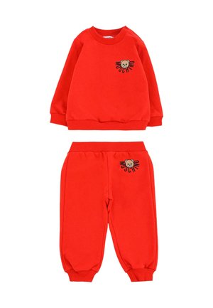 Czerwony bawełniany dres dziecięcy składający się z bluzy z ściągaczami oraz haftowanym motywem misia, w zestawie z dopasowanymi spodniami.