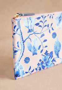 Rožinė gėlių raštų užtrauktuko kosmetinė su mėlynais botanikiniais raštais. Pagaminta iš patvarios medžiagos, pasižymi lygiu paviršiumi ir auksinės spalvos detalėmis.