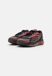Black running shoes with red accents, featuring a mesh upper, textured lines, and a cushioned sole for shock absorption.