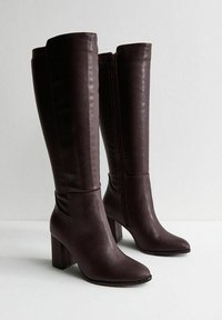 Botas altas hasta la rodilla de cuero marrón con punta cuadrada y tacón ancho, que cuentan con una cremallera lateral y una textura suave.