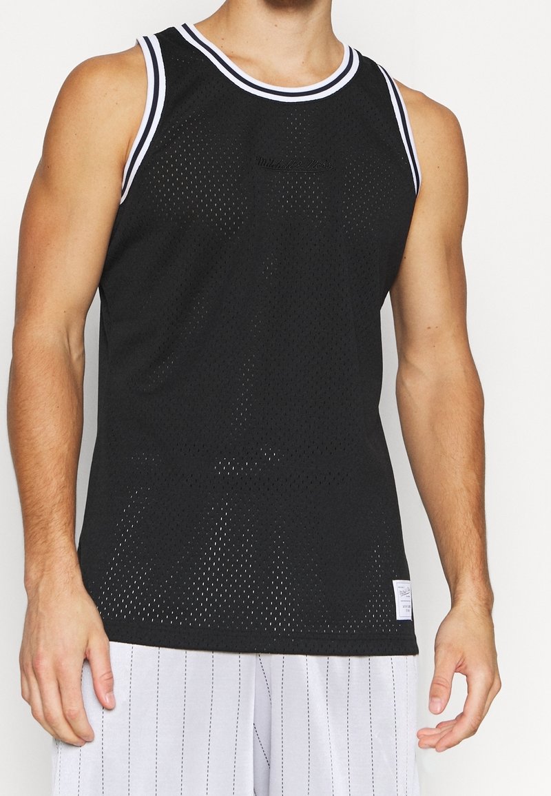 Débardeur en maille noire avec bordure blanche à rayures, présentant une coupe ample et un logo de marque discret au centre. Tissu léger et respirant.