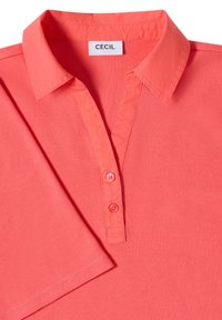 Chemise rose corail à manches trois quarts, col, deux boutons et étiquette de marque « CECIL » cousue à l'intérieur de l'encolure.