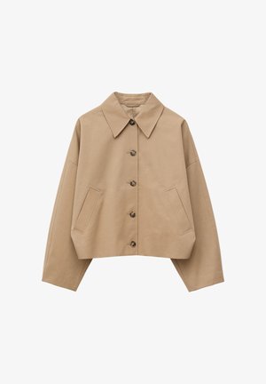 Veste courte beige avec col large pointu, boutons marron sur le devant, manches longues et poches fendues en biais de chaque côté.
