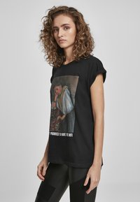 Schwarzes Baumwoll-T-Shirt mit einem bedruckten Artwork in der Mitte und einer weißen Textunterschrift darunter. Kurze Ärmel, lockere Passform, glatte Textur.