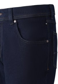 Dunkelblaue Denim-Jeans mit Front- und Seitentaschen, sichtbaren Nähten und Metallnieten an den Taschenkanten.