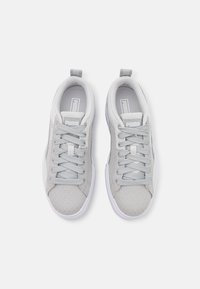 Sneaker in tessuto grigio con tomaia testurizzata, chiusura con lacci e linguetta imbottita. Presenta suole in gomma bianca e un logo sulla linguetta.