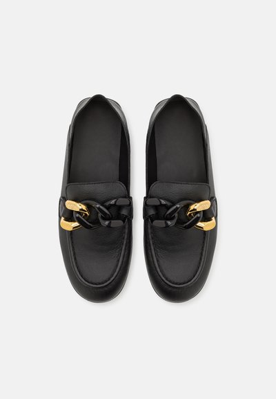 Los mocasines de cuero negro presentan una textura suave, forma redondeada y herrajes en tono dorado con un acento de cadena negra a lo largo del empeine.