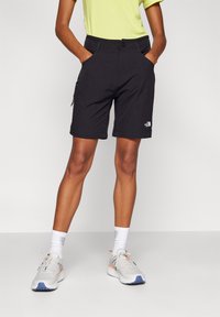 Schwarze Shorts mit Reißverschlusstasche, gefertigt aus leichtem Stoff. Verfügen über einen Knopfverschluss und ein Logodetail an der unteren Seite.