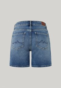 Pantalones cortos de mezclilla en azul claro, con una cintura alta, dos bolsillos traseros con un patrón de olas y una etiqueta de cuero texturizado en la cintura.