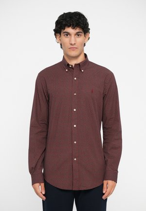 Red and navy patterned long-sleeve shirt with a button-down collar, featuring a pocket with a small logo and white buttons along the placket.
