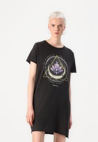 Svart bomull T-shirt klänning med en grafisk design som har en lotusblomma inom en triangel. Korta ärmar och en avslappnad passform.