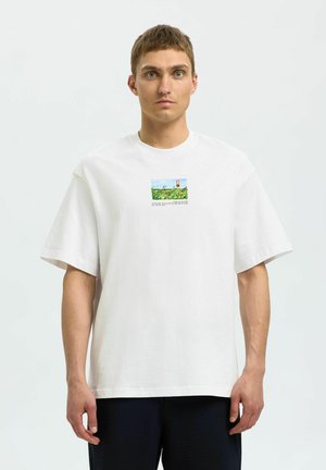 Hvid bomulds T-shirt med korte ærmer, der har et lille farverigt grafisk motiv af et landskab på brystet. Lige kant og afslappet pasform.
