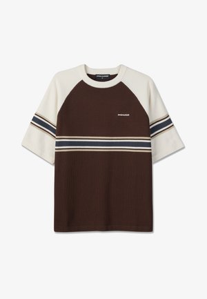 Lühikeste varrukatega kootud särk, millel on pruun kere, valged varrukad ja õlapaneelid, tumerohelised ja beežid horisontaalsed triibud ning väike "PEGADOR" logo rinnal.