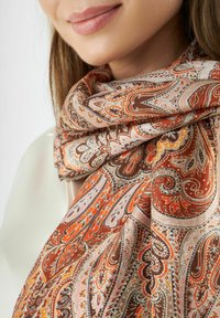Zijden sjaal met een ingewikkeld paisleypatroon in bruin, oranje en lichtroze tinten. Zachte textuur, gelaagd ontwerp rondom de nek.