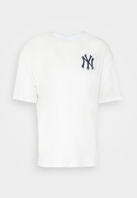 Biała bawełniana koszulka z okrągłym dekoltem, krótkimi rękawami i granatowym logo po lewej stronie klatki piersiowej. Klasyczny, luźny krój.