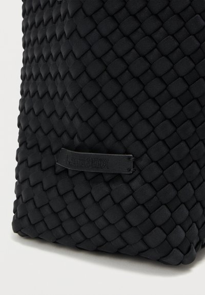 Μαύρη υφασμάτινη τσάντα με υφαντό, υφή και διακοσμητικό μοτίβο. Διαθέτει μικρή ετικέτα με το όνομα της επωνυμίας.