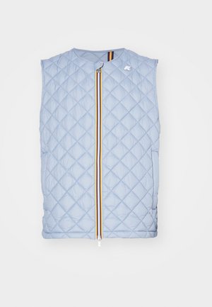 Nabierana niebieska kamizelka na żółtej kurtce i żółtych spodniach cargo. Czarne masywne buty. Gładka tekstura, kontrastujące kolory oraz funkcjonalny design.