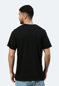 T-shirt in cotone nero, maniche corte, scollatura classica a girocollo, vestibilità morbida, texture liscia, senza motivi o accessori visibili.