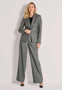 Grijs gestreept kostuum met een op maat gemaakte blazer en brede broekspijpen, gemaakt van textuurstof, met een enkele knoopsluiting.