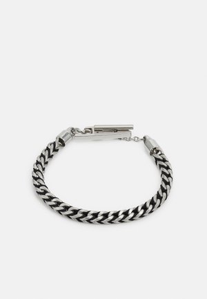 Pulseira em metal de tom prateado com segmentos entrelaçados em preto e prateado, apresentando fecho e textura suave.