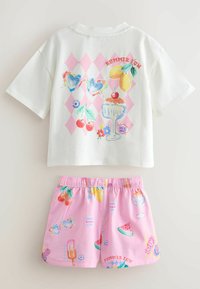 Witte top met korte mouwen, roze ruitmotief en zomerillustraties, gecombineerd met roze shorts met elastische taille en bijpassende kleurrijke prints.