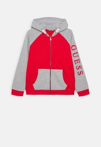 Rode en grijze hoodie met rits, een kangoeroezak, capuchon en raglanmouwen. Bevat "GUESS" in het rood gedrukt op de grijze mouw.