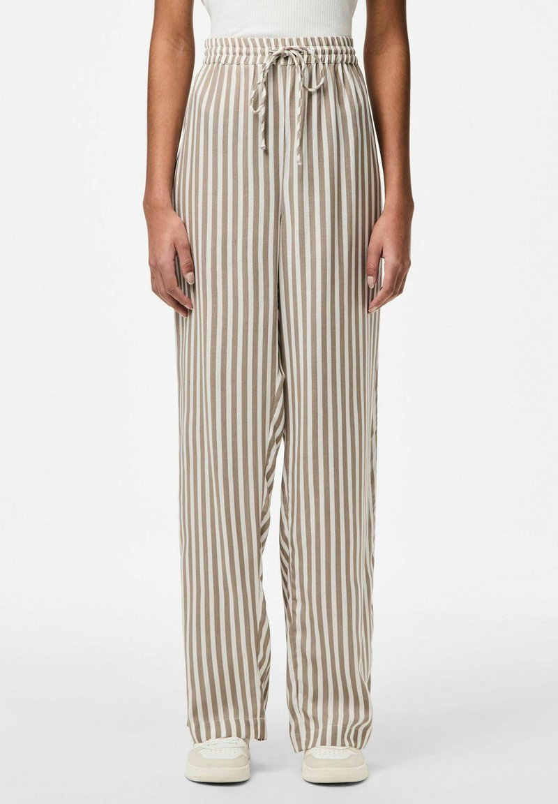 Lichte, wijde broek in beige met witte verticale strepen. Voorzien van een elastische tailleband met een trekkoord voor een verstelbare pasvorm.