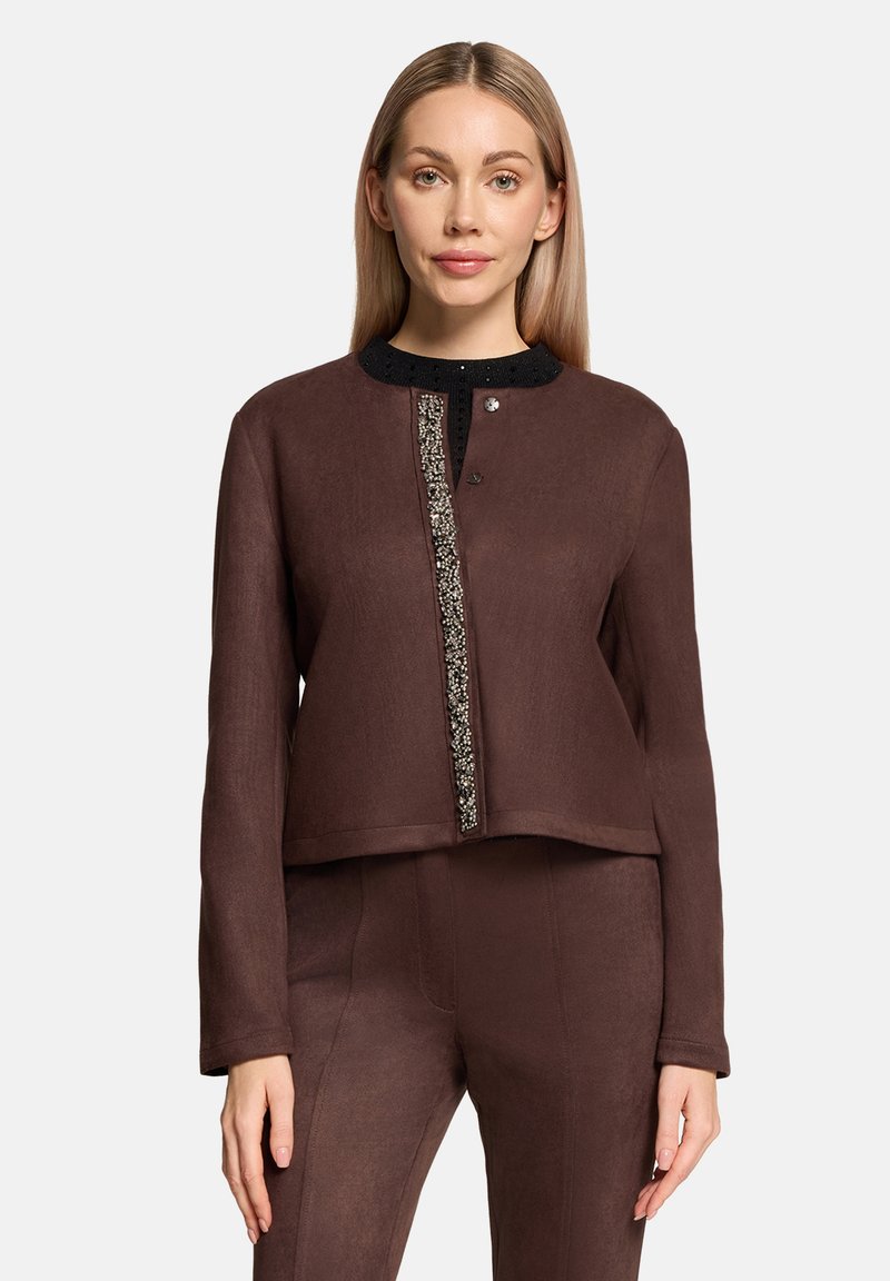 Brązowa krótka kurtka z czarnym zdobionym kołnierzem, z przodem na guziki oraz teksturowanym materiałem z pionowym dekoracyjnym panelem.