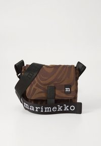 Bruine crossbodytas met patroon en klepsluiting, zwarte band met het "marimekko"-logo, en een klein zwart merkje aan de voorkant.