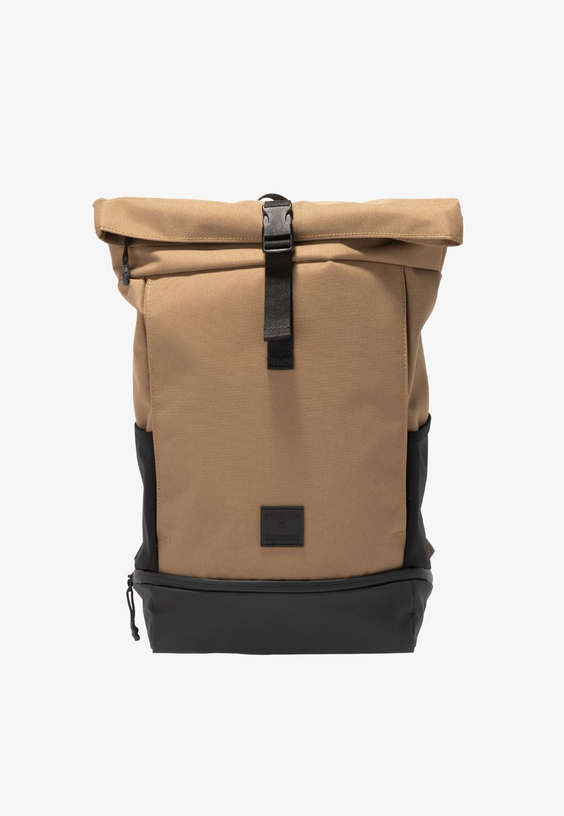 Béžovo-černý batoh s rolovacím uzávěrem, přední sponou a na zip uzavíratelným spodním oddílem, stojící vzpřímeně na bílém pozadí.
