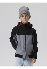 Grau und schwarze Reißverschlussjacke mit elastischen Bündchen, orangefarbiger Innenseite und zwei Seitentaschen, kombiniert mit einer grauen Strickmütze.